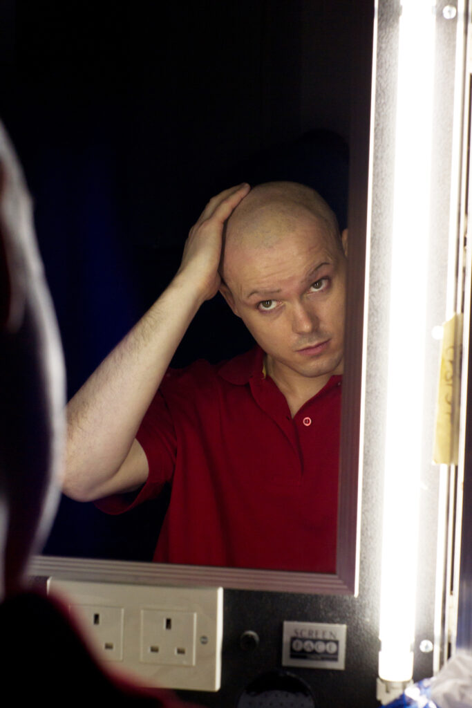Actor on the set of final punchline looking in the mirror
