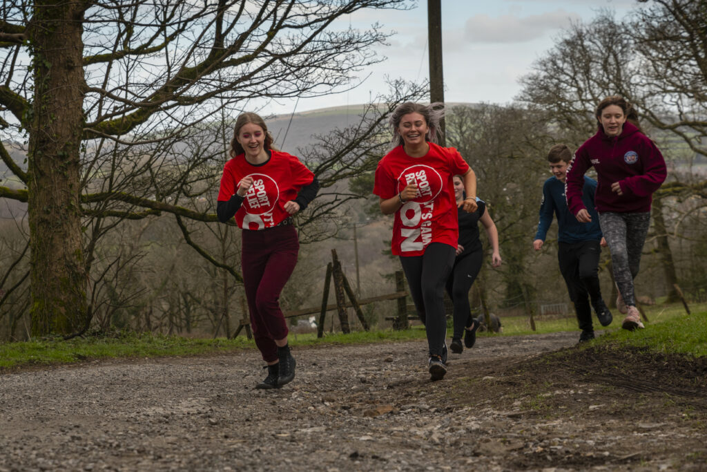 Girls running up a hill